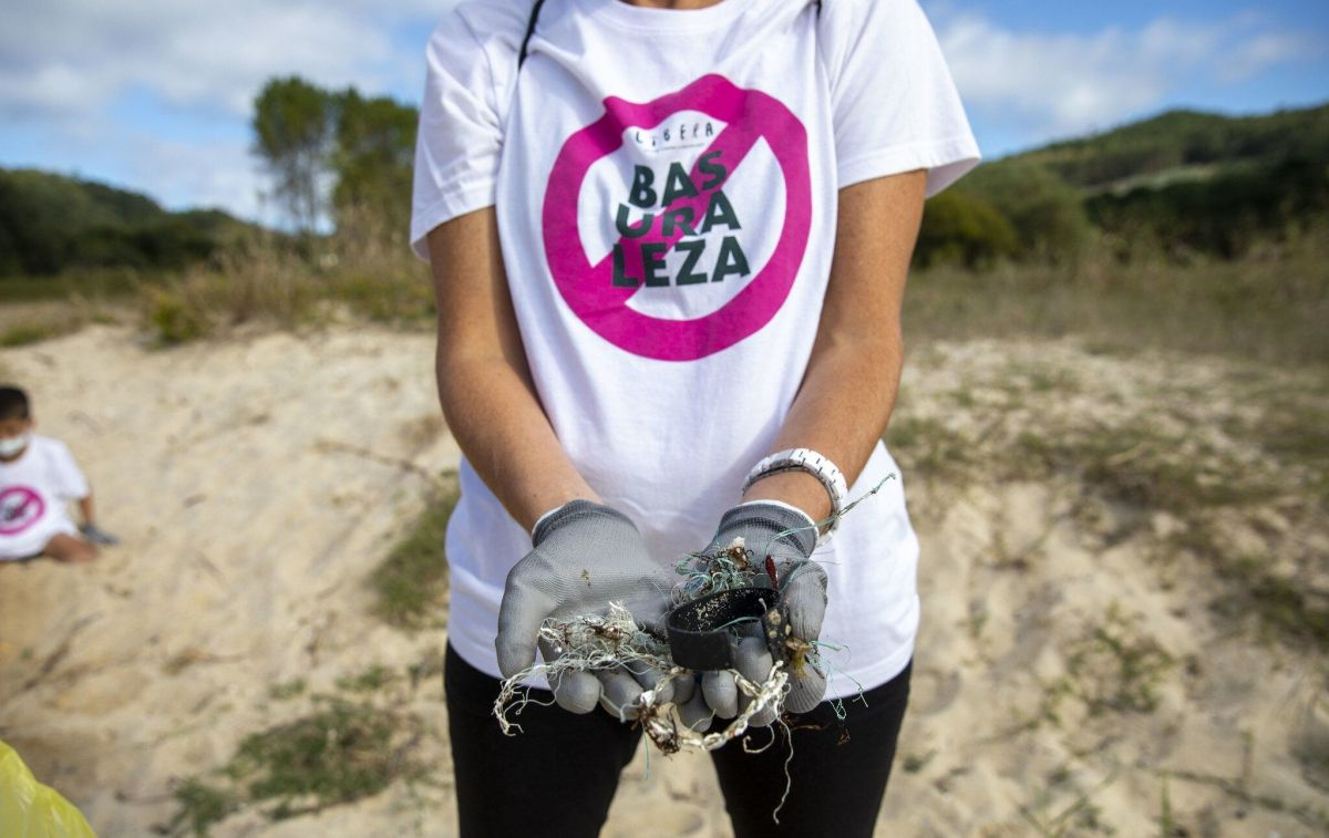 Una activista medioambiental que limpia una playa / EP