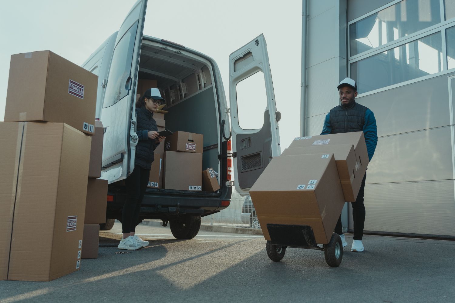 Dos personas cargan una furgoneta en un centro de 'e-commerce' / PEXELS