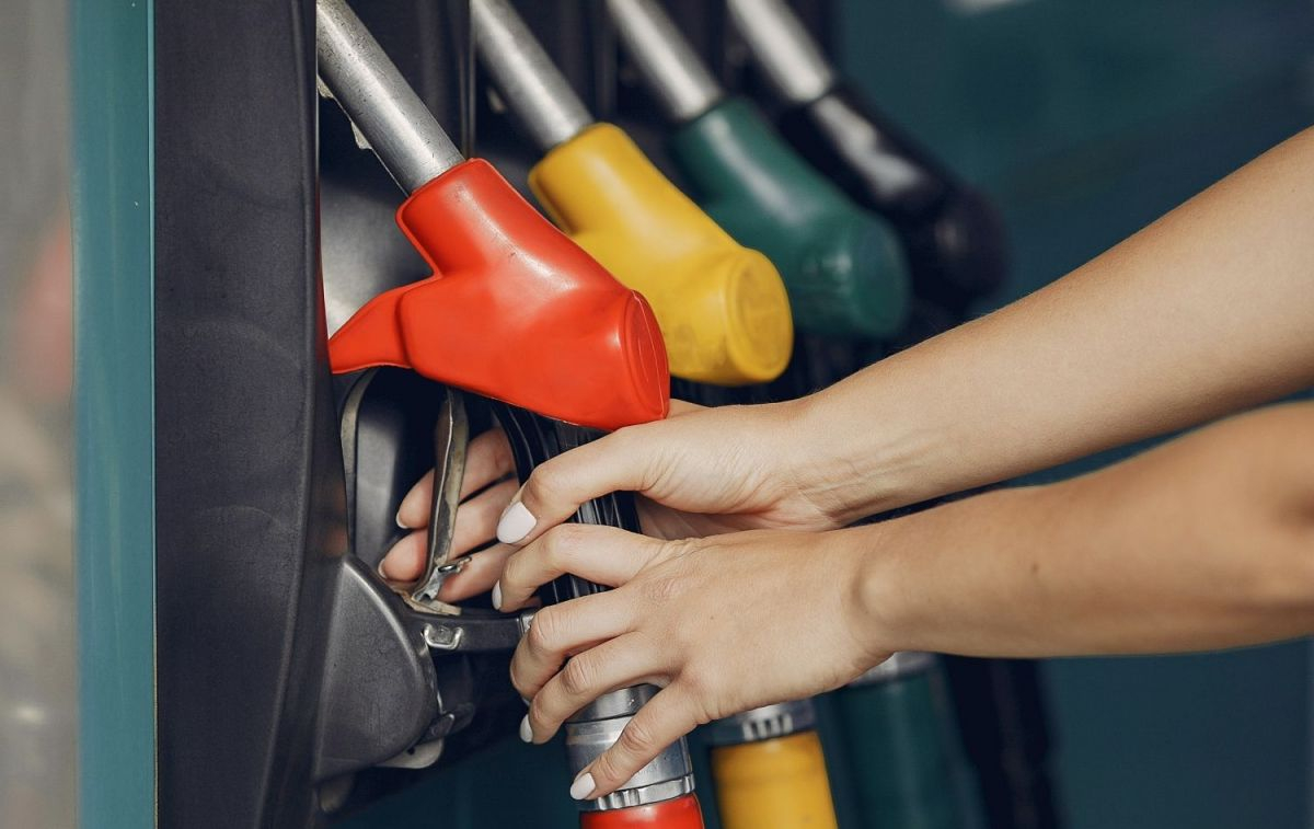 Una mujer coge uno de los dispensadores de gasolina para llenar el depósito de su coche / PEXELS