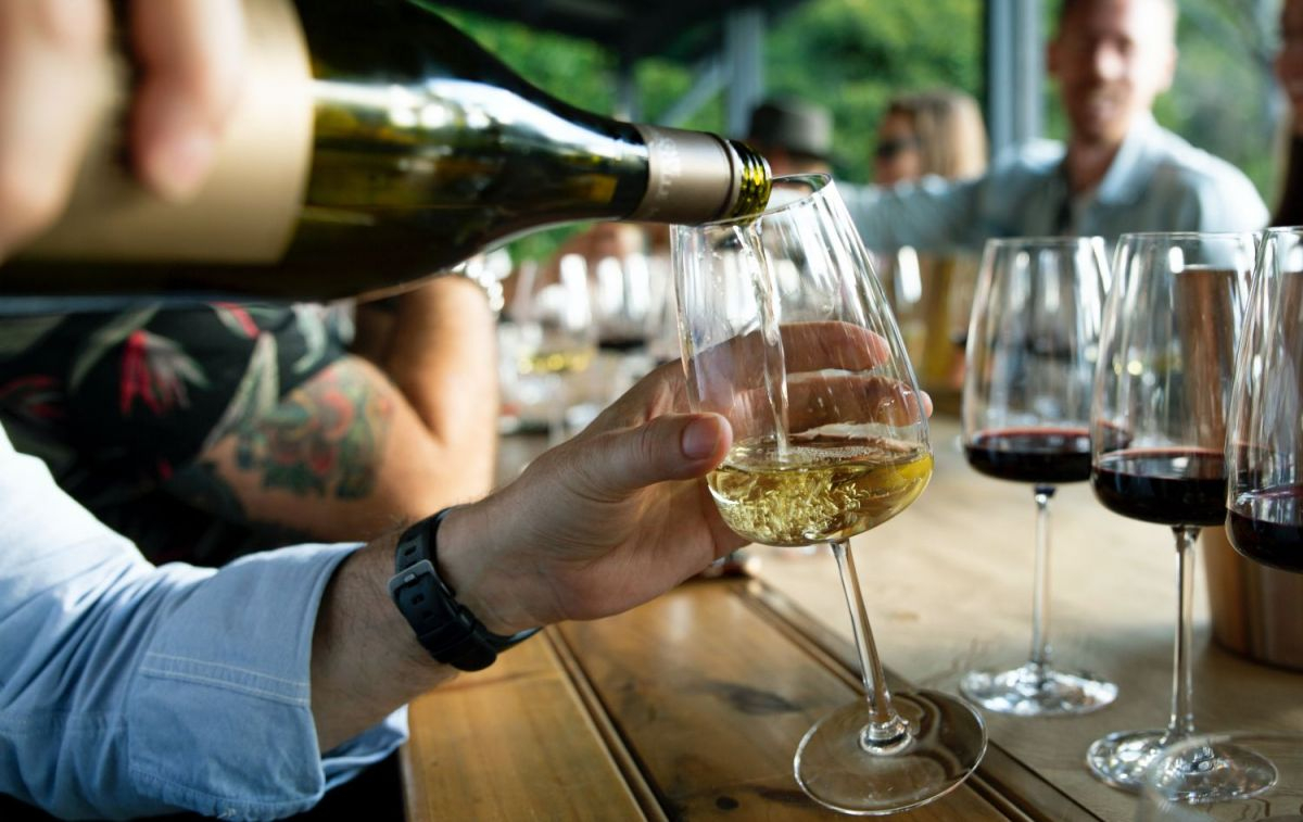 Una persona sirve una copa de vino en una bodega / UNSPLASH Una persona sirve una copa de vino en una bodega / UNSPLASH