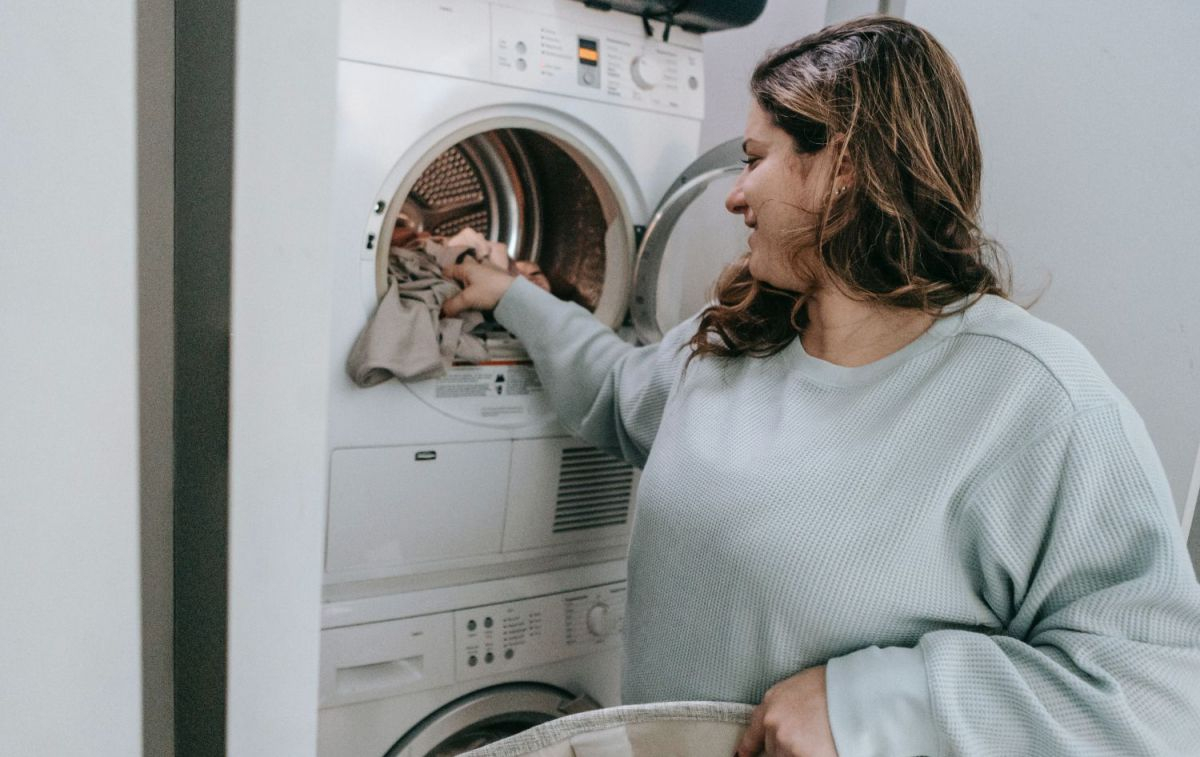Una mujer pone una lavadora, uno de los electrodomésticos que más luz consume / PEXELS