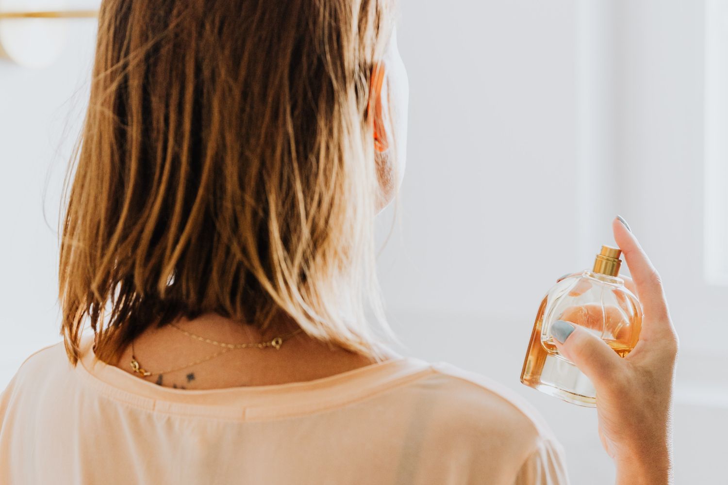 Una mujer usa un perfume / UNSPLASH Una mujer usa un perfume / UNSPLASH