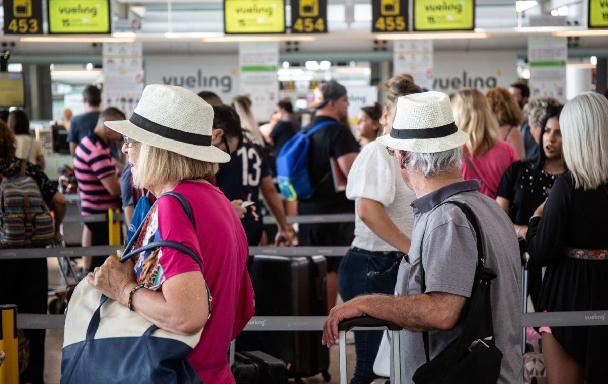 Diferentes viajeros esperan en el aeropuerto para subir a una avión de Vueling / EP