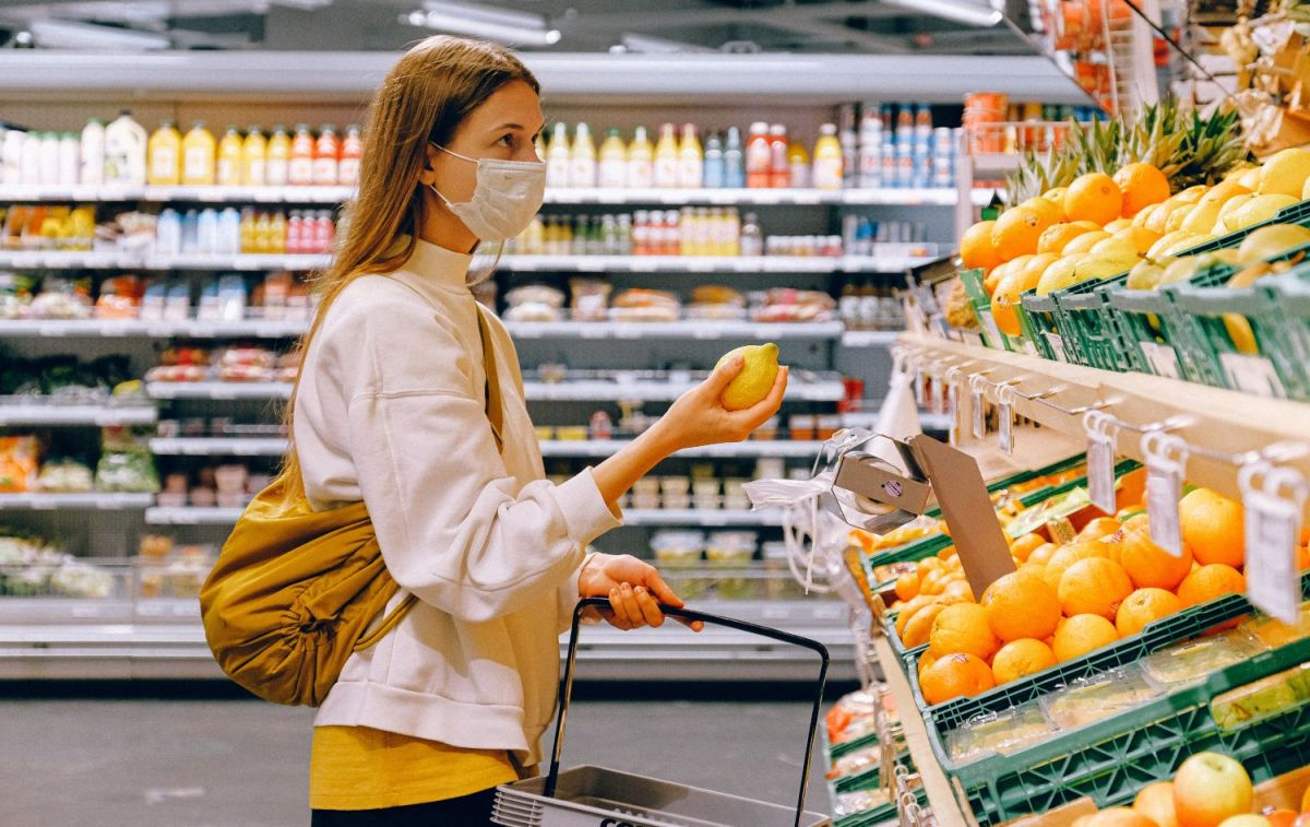 Una mujer en la sección de frutas y hortalizas del supermercado / PEXELS