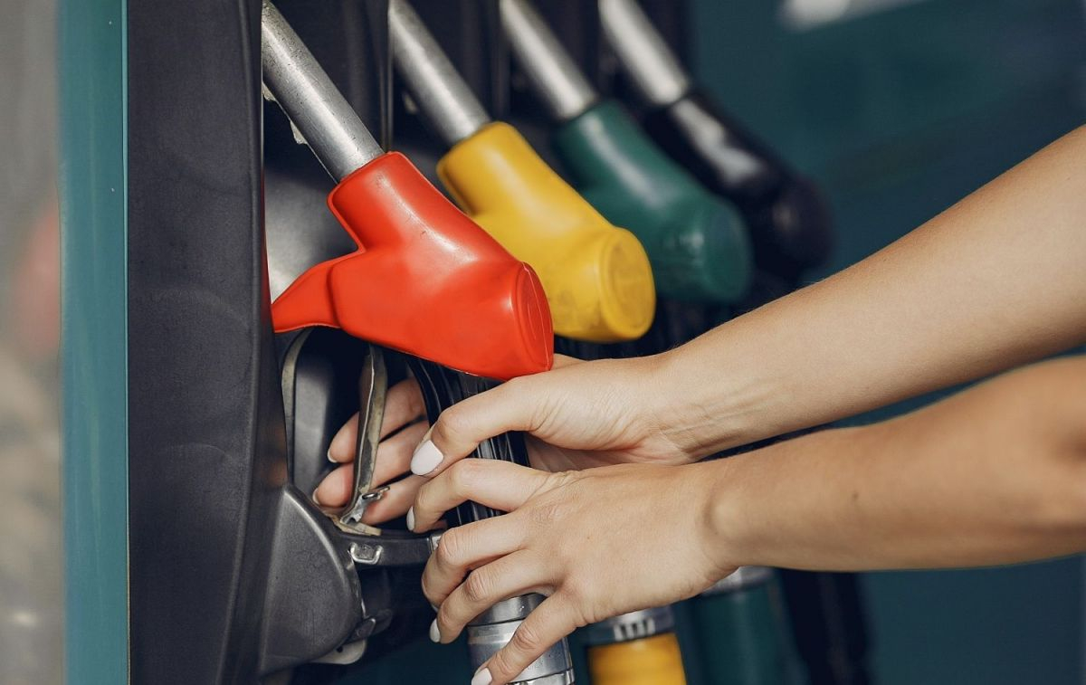 Una persona coge un dispensador de gasolina para llenar el depósito de su vehículo / PEXELS