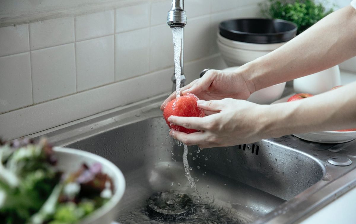 Una mujer lava  la fruta, un método para prevenir intoxicaciones como la de Buitoni / PEXELS