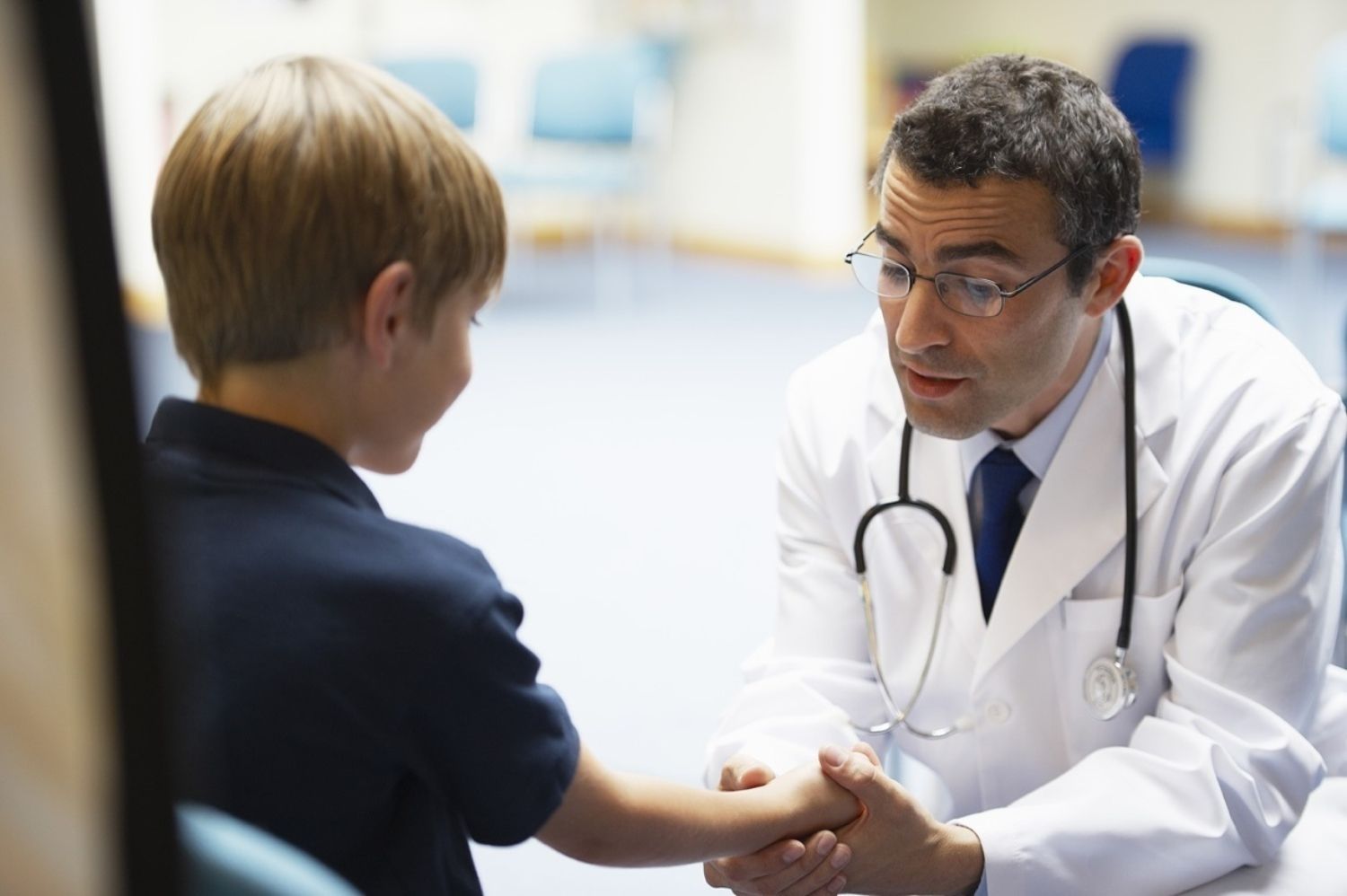 Un médico con un niño en una consulta de pediatría / EP