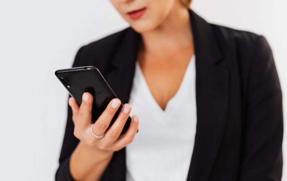 Una mujer leyendo un SMS en el móvil / PEXELS