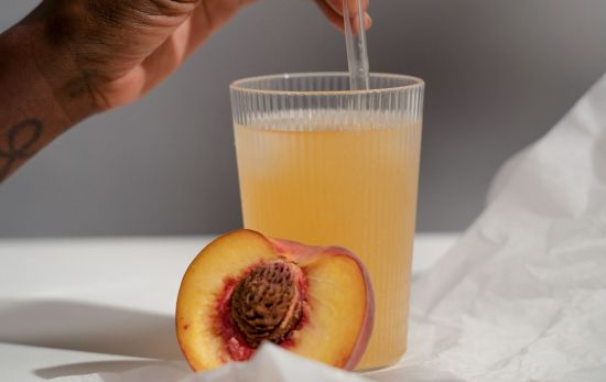 Un vaso de cristal con zumo natural de melocotón / PEXELS