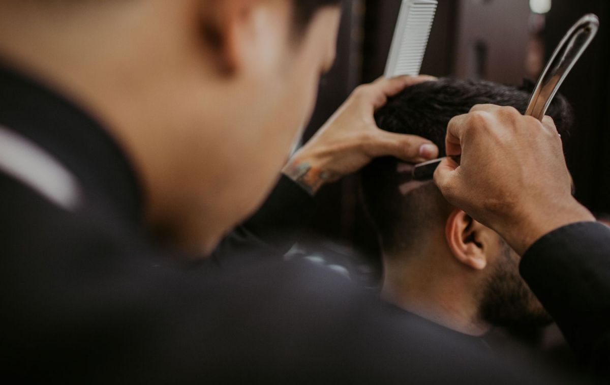 Un peluquero realiza un corte de pelo / PEXELS