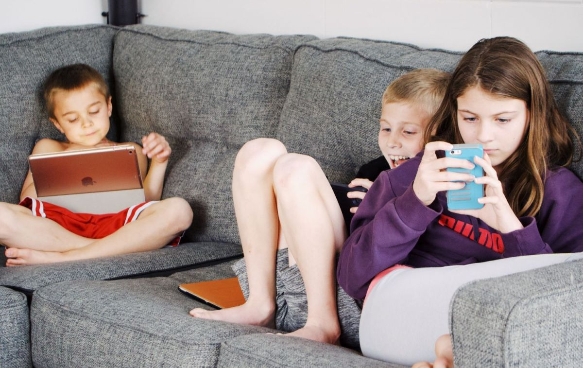 Tres niños juegan con sus smartphones / PEXELS