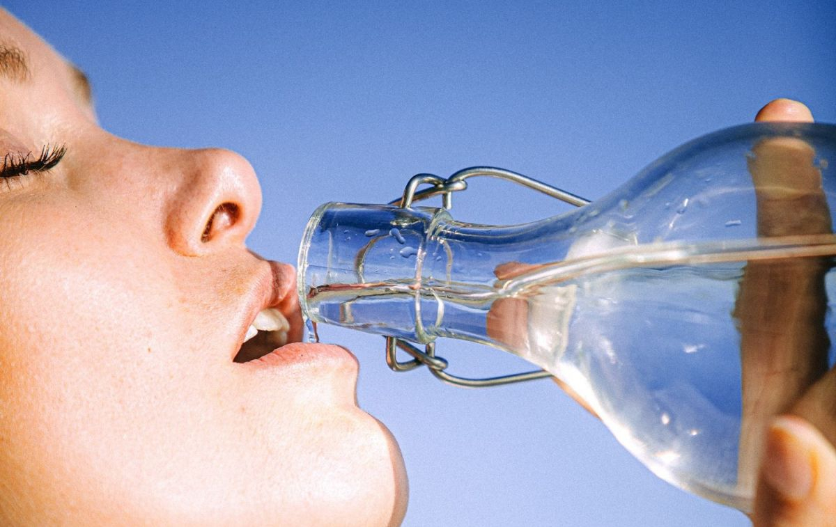 Una persona bebe agua de una botella para evitar la deshidratación / PEXELS