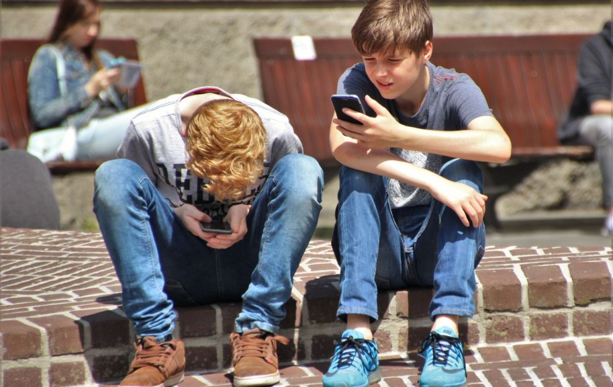 Dos niños consultan las redes sociales desde sus móviles / PEXELS