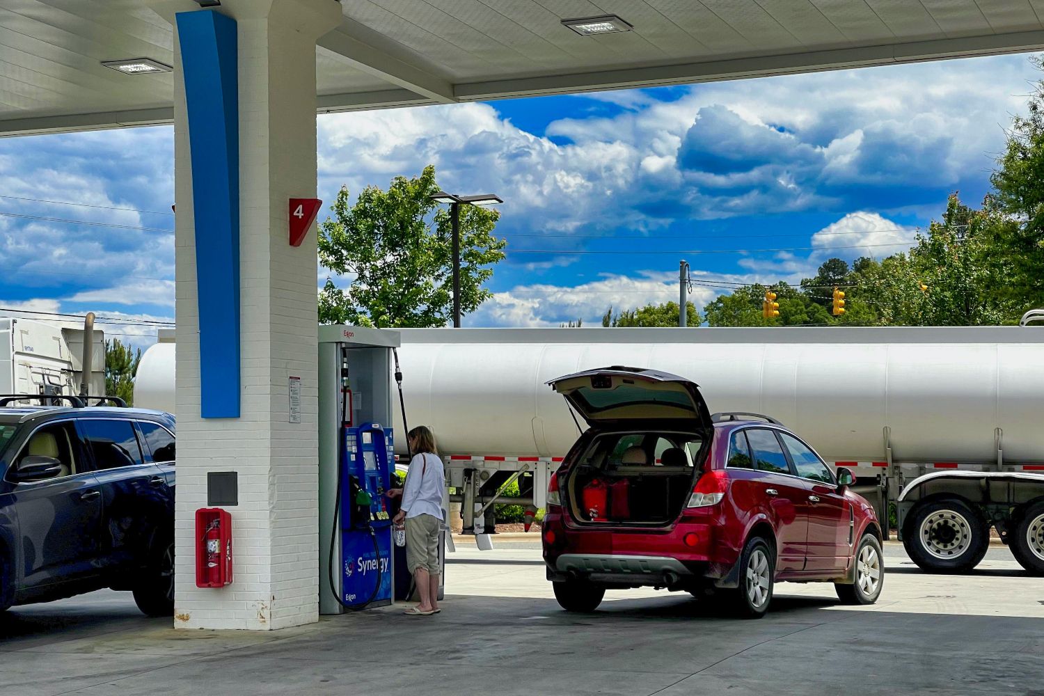 Una persona en una gasolinera con el precio del diésel y la gasolina disparados / UNSPLASH