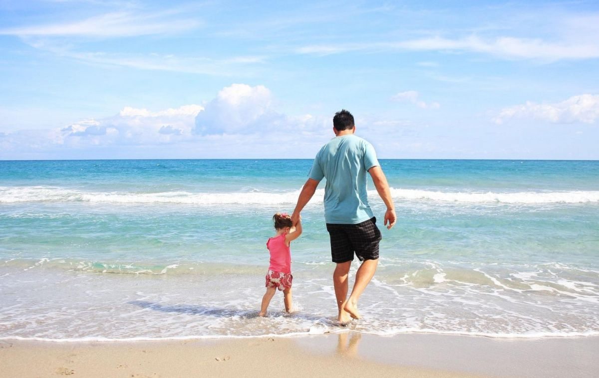 Un padre con su hija en la playa en verano / PIXABAY