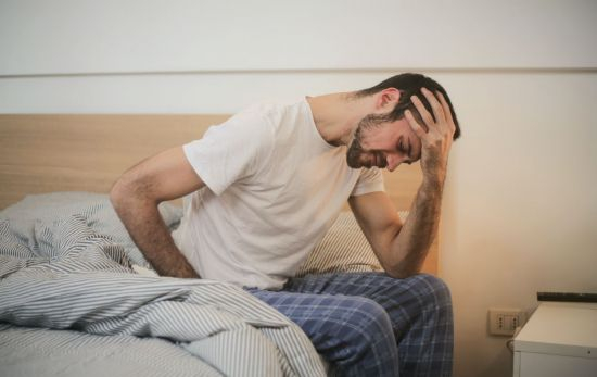 Una persona con cansancio y dolor estomacal cuando tiene que ir a trabajar / PEXELS