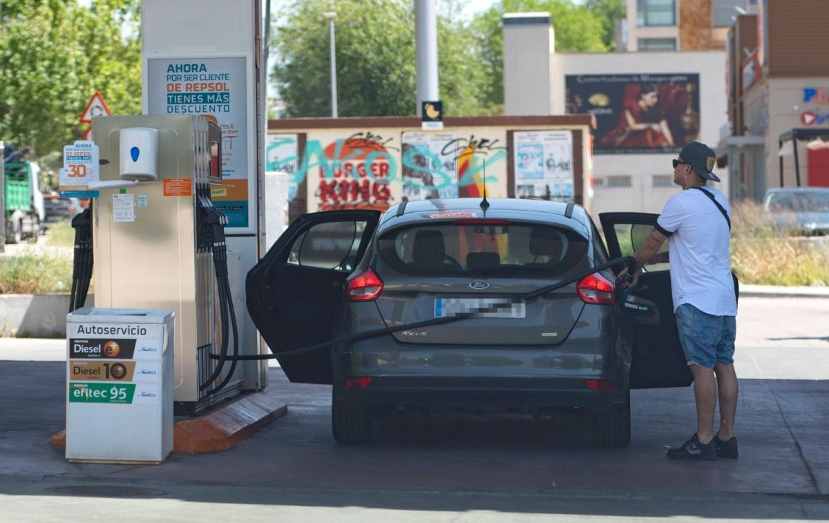 Un consumidor llena el depósito de su coche de gasolina en una gasolinera / EP