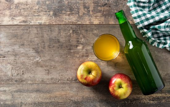 Una botella y un vaso de sidra junto a dos manzanas / FREEPIK Una botella y un vaso de sidra junto a dos manzanas / FREEPIK