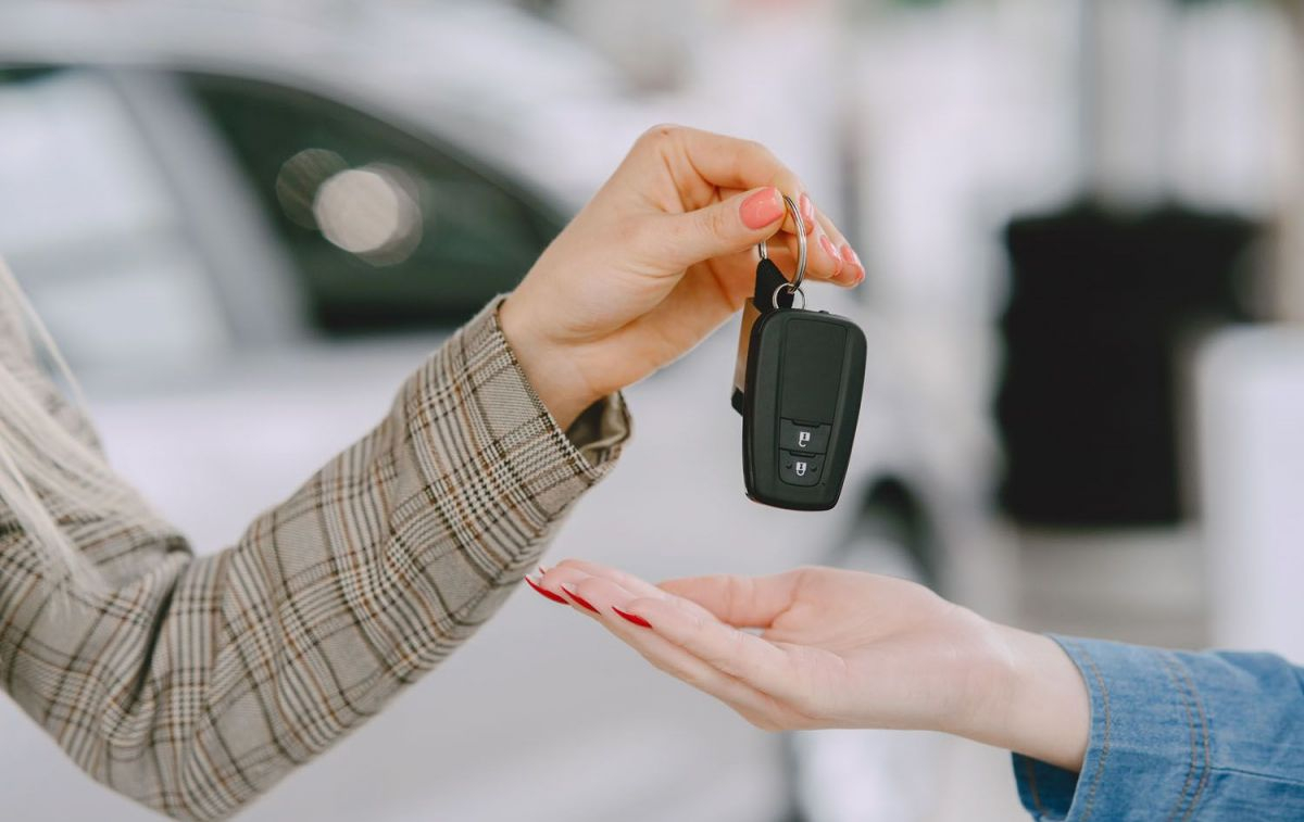 Una empleada entrega las llaves de un coche de alquiler / FREEPIK