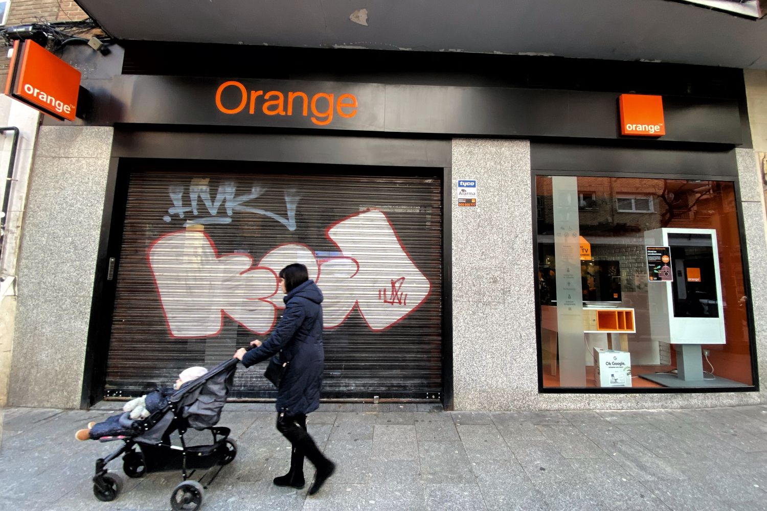 Una mujer pasa frente a una tienda de Orange / EDUARDO PARRA - EUROPA PRESS Una mujer pasa frente a una tienda de Orange / EDUARDO PARRA - EUROPA PRESS