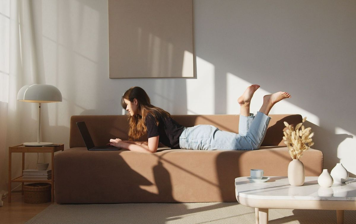 Una chica con su ordenador en el sofá / PEXELS