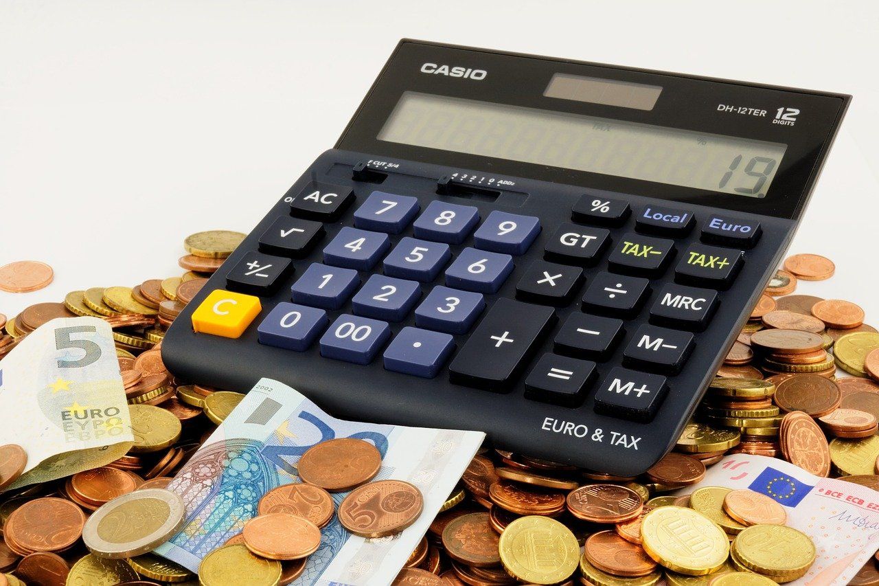 Una calculadora y dinero en monedas y billetes / PIXABAY