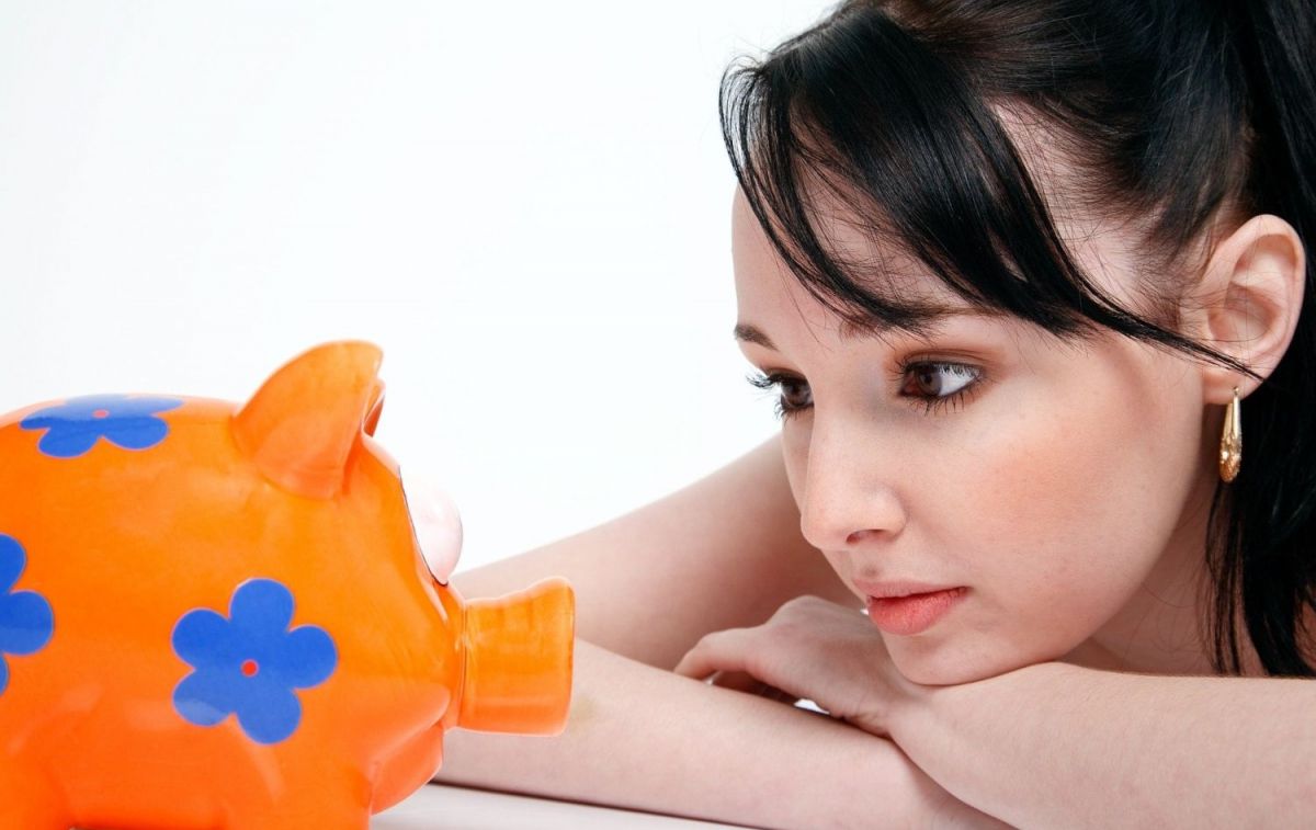 Una mujer mira una hucha con sus ahorros / PIXABAY