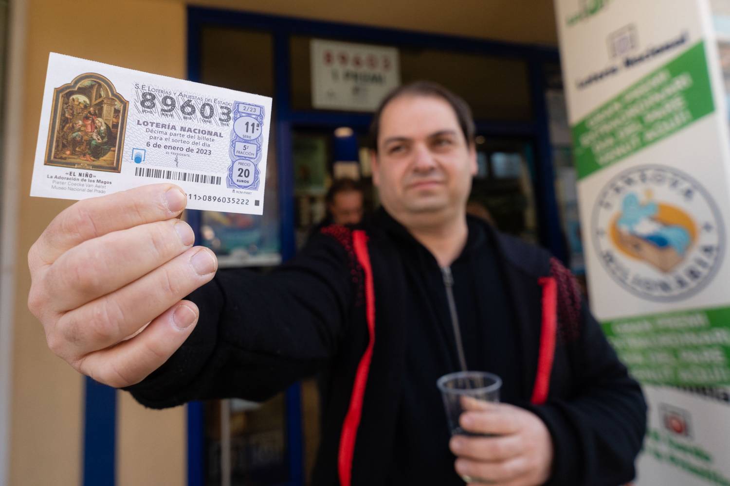 Un agraciado con el primer premio del Sorteo del Niño 2023 muestra el décimo / EFE