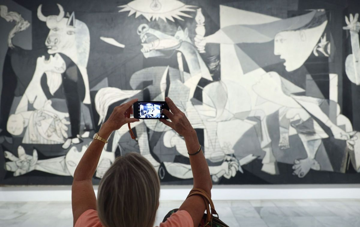 Una mujer fotografía la obra de Picasso 'Guernica' durante la presentación de los actos conmemorativos del Año Picasso, en el Museo Reina Sofía / EDUARDO PARRA EP