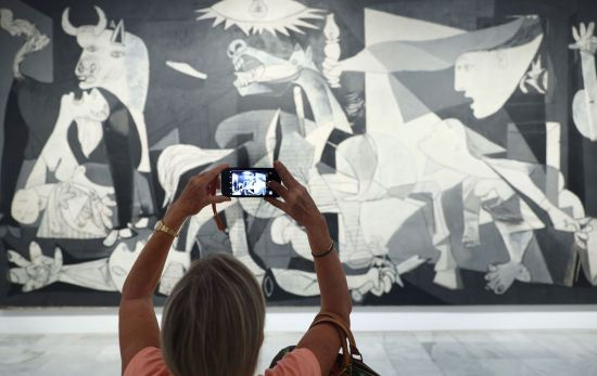 Una mujer fotografía la obra de Picasso 'Guernica' en el Museo Reina Sofía / EDUARDO PARRA - EP Una mujer fotografía la obra de Picasso 'Guernica' en el Museo Reina Sofía / EDUARDO PARRA - EP