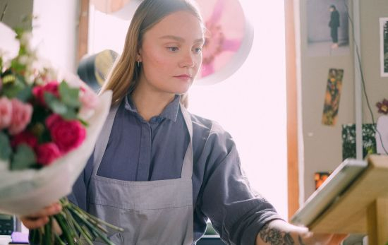 Una trabajadora de un negocio asociado a Interflora prepara un ramo / PEXELS