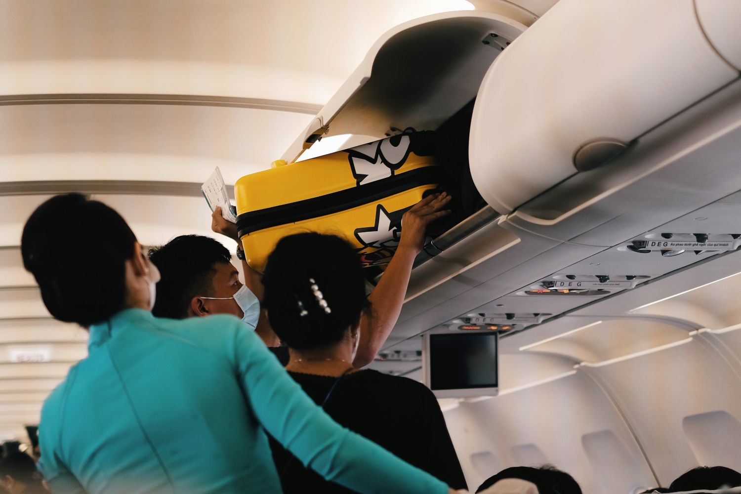 Un pasajero coloca su maleta de cabina y su equipaje de mano en un avión / PEXELS