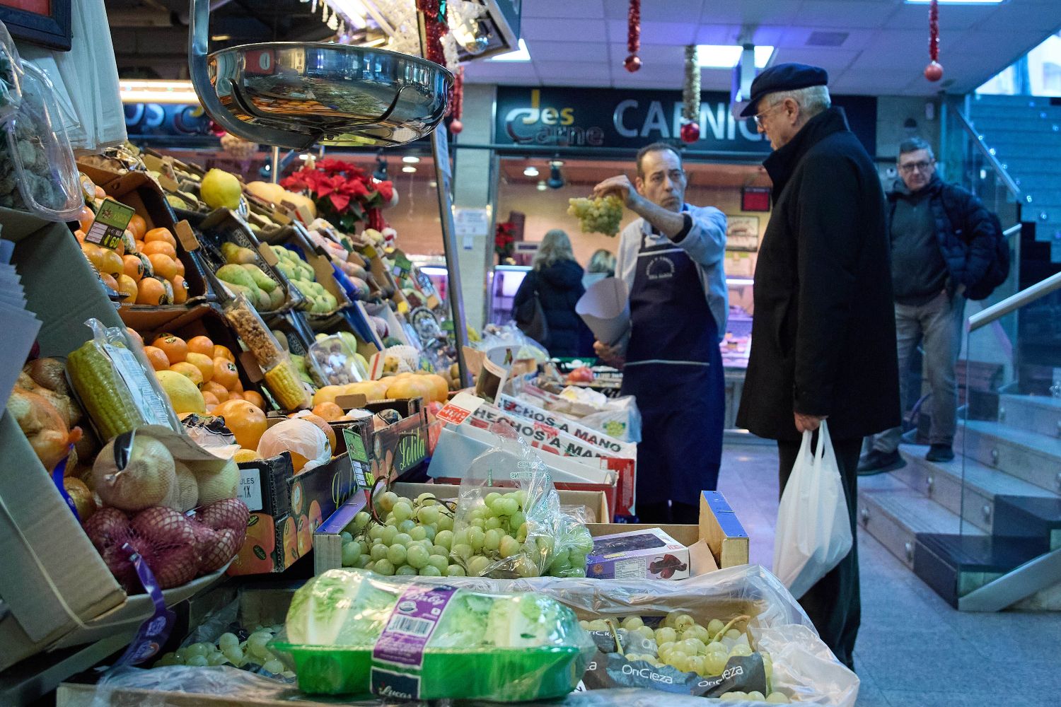 Un consumidor comprueba la subida de precio de los alimentos en una frutería de Madrid / EUROPA PRESS - JESÚS HELLÍN