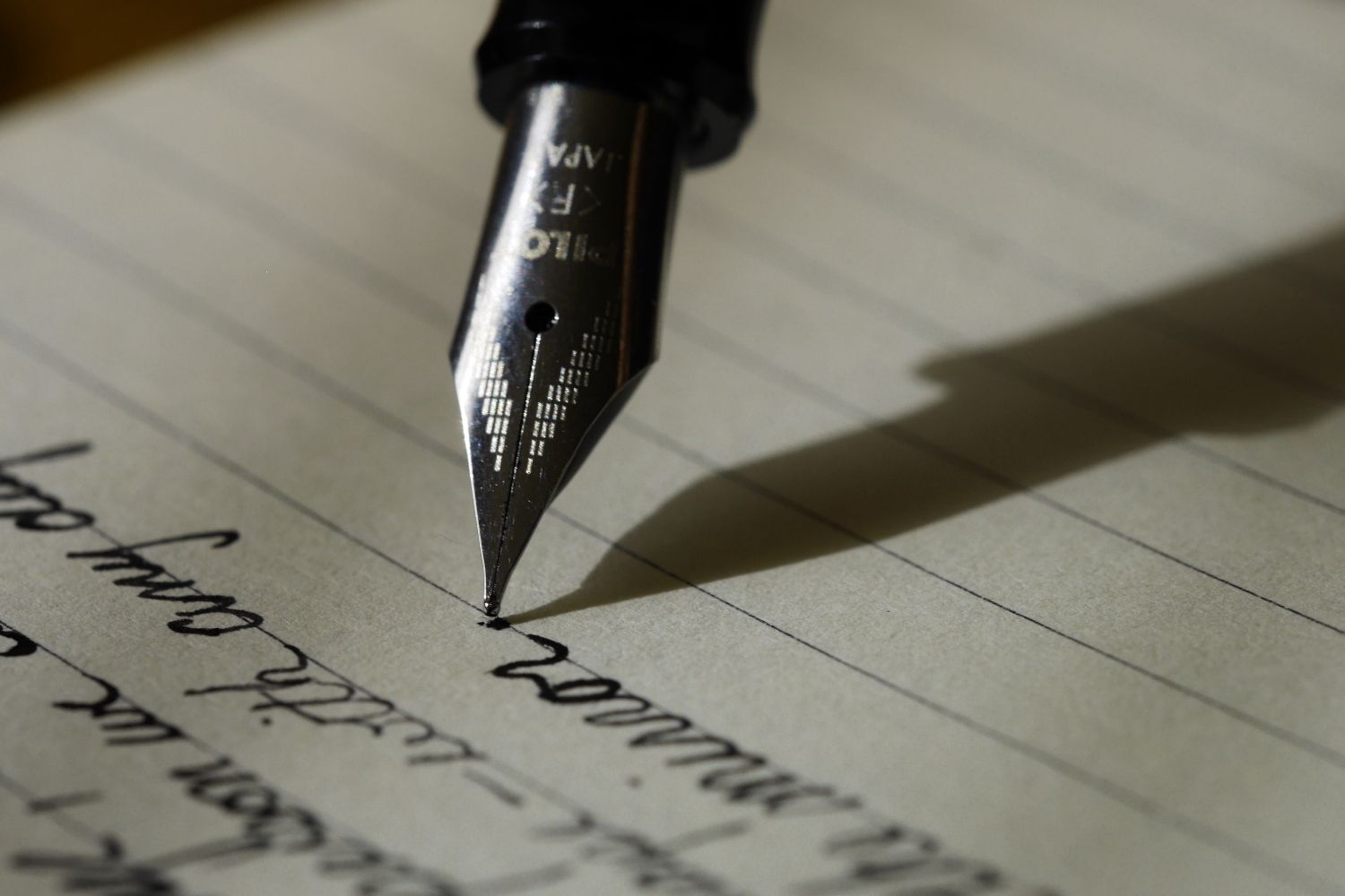 Una persona escribe un libro con una pluma / UNSPLASH