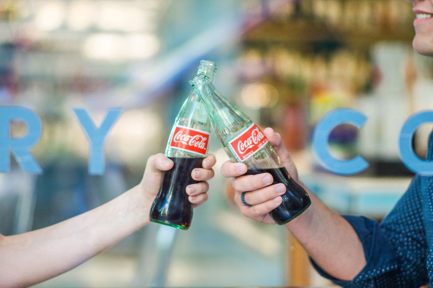 Dos personas brindan con Coca-Cola / UNSPLASH Dos personas brindan con Coca-Cola / UNSPLASH