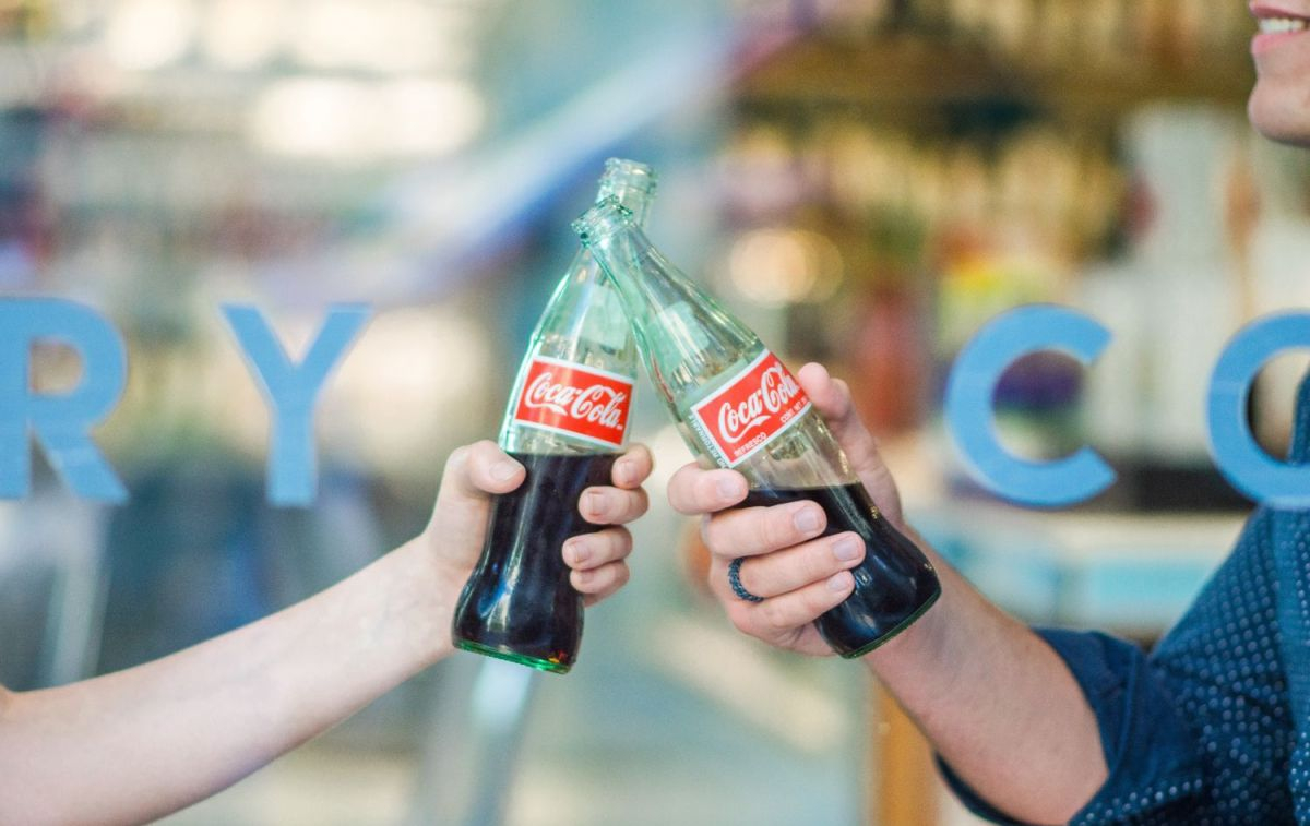 Dos personas brindan con Coca-Cola / UNSPLASH