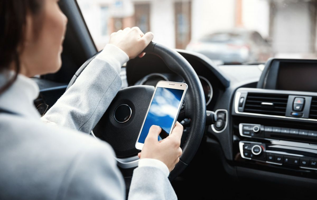 Una usuaria de BlaBlaCar mira su móvil dentro de su coche / FREEPIK -@lookstudio