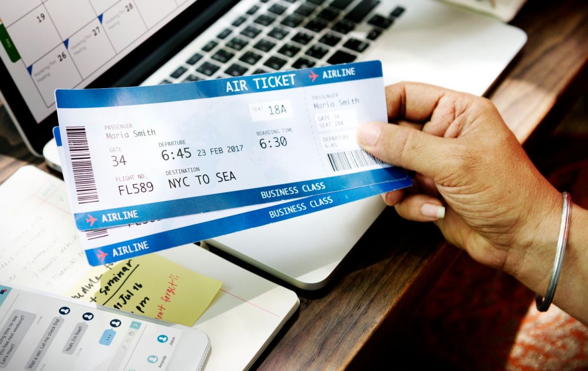 Una persona con billetes de avión / FREEPIK