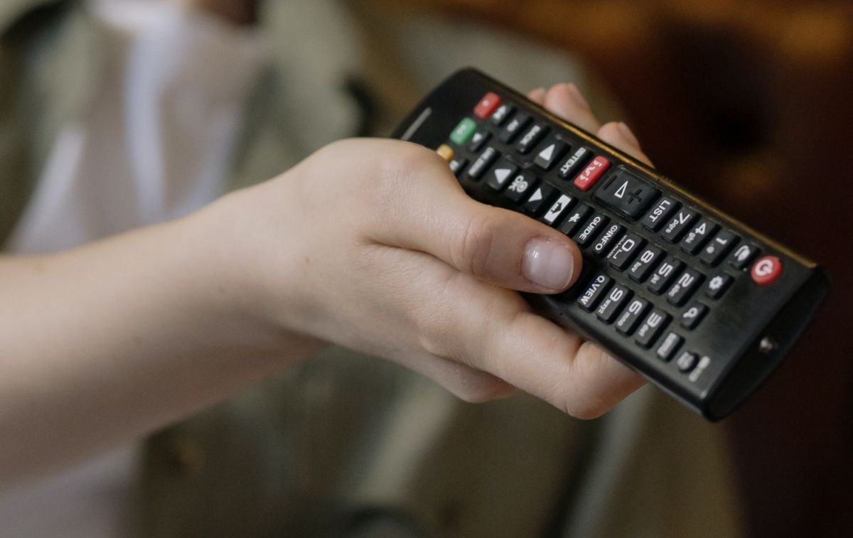 Una persona utiliza un mando para poner Movistar+ en su televisor / PEXELS