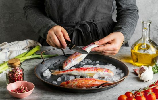 Una persona prepara un pescado / FREEPIK Una persona prepara un pescado / FREEPIK
