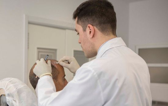 Un médico realiza un tratamiento contra la calvicie / EP Un médico realiza un tratamiento contra la calvicie / EP