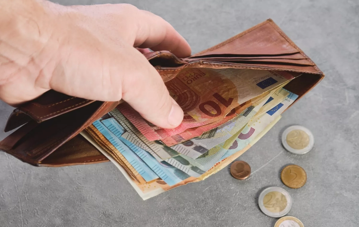 Una persona muestra el dinero en efectivo que lleva en su cartera / FREEPIK