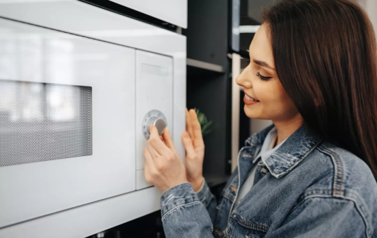 Una mujer junto al microondas / FREEPIK Una mujer junto al microondas / FREEPIK