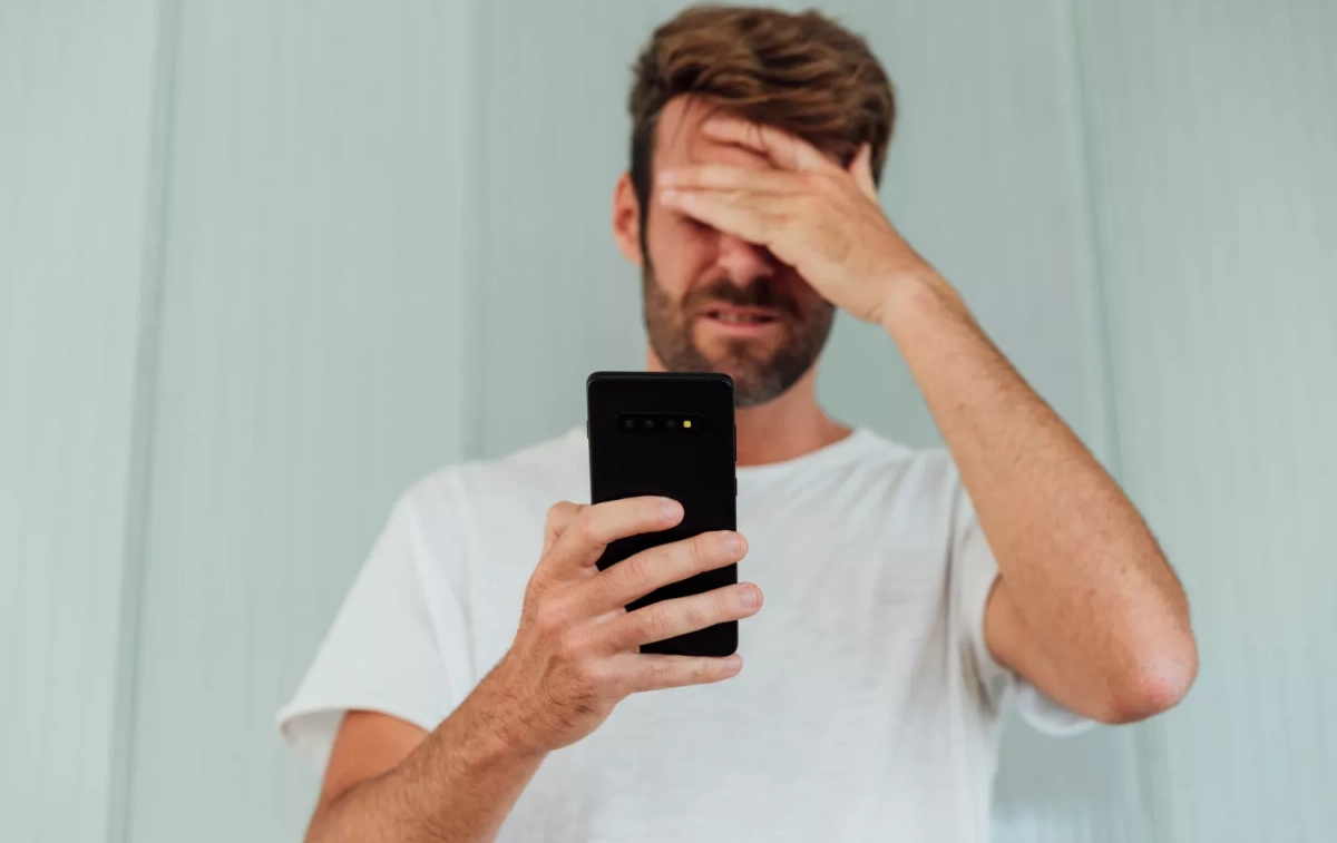 Un hombre frustrado con Esdorado sostiene su teléfono / FREEPIK