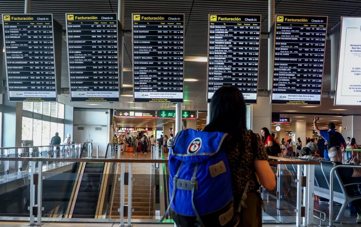 Una mujer observa los paneles informativos de los vuelos cancelados en el Aeropuerto Adolfo Suárez - Madrid Barajas / EP