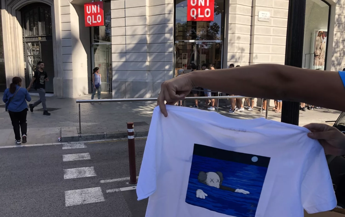 Un cliente muestra su camiseta Kaws frente a la tienda Uniqlo / CG