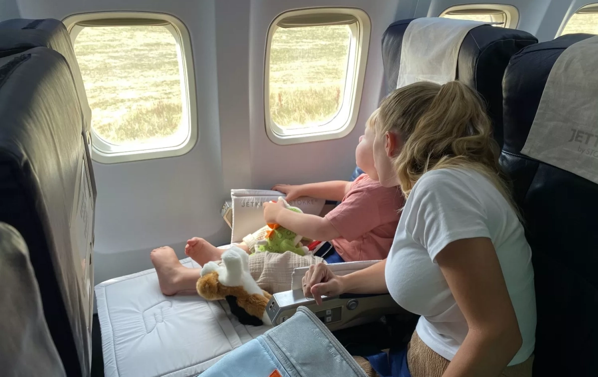 Un niño junto a su madre montando en una avión / PEXELS