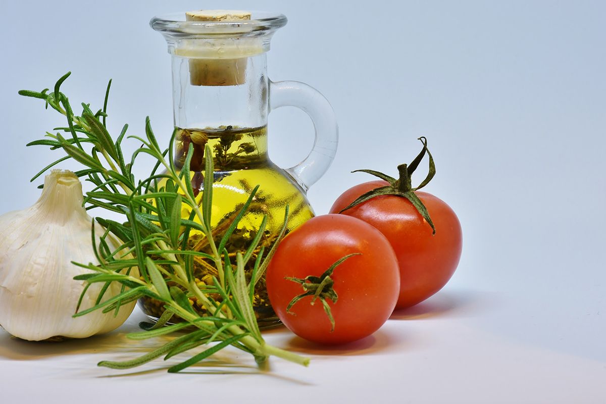 Una botella de aceite, tomates y ajo / PIXABAY