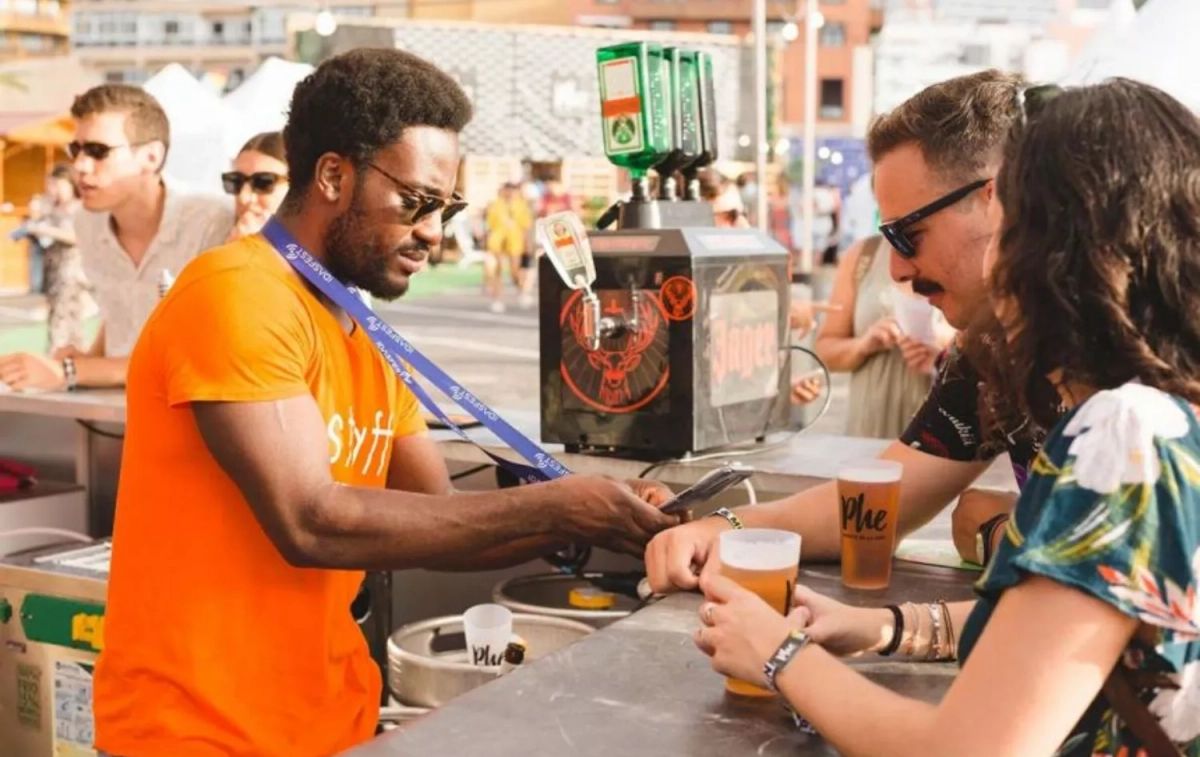 Un camarero cobra una bebida mediante el sistema 'cashless' de un festival / IDASFEST