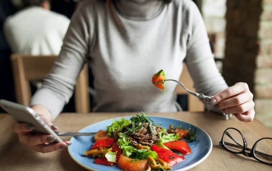Una mujer come un plato de comida vegetal / FREEPIK Una mujer come un plato de comida vegetal / FREEPIK